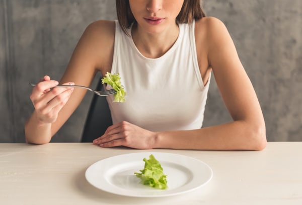Slender Young Woman Eating Lettuce