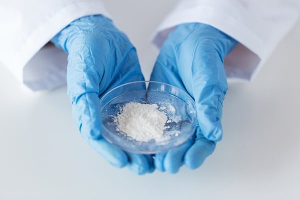 Scientist Holding a Small Bowl of White Powder